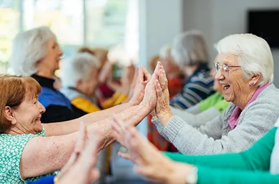 Elderly women clapping hands and smiling