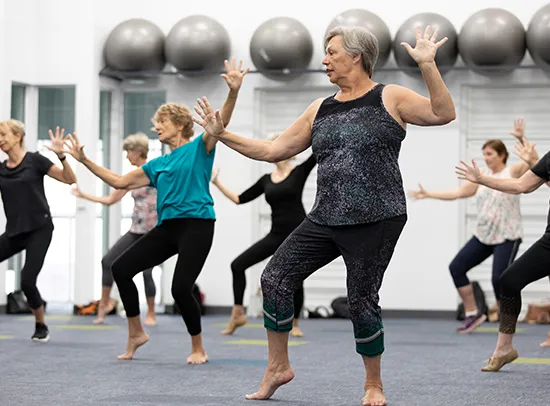 Group of older women in dance studio doing dance moves