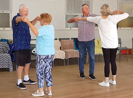 Two older couples learning dance moves